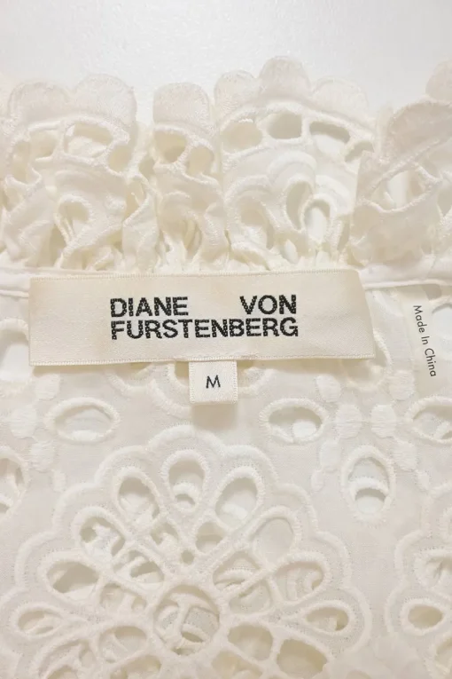 White broderie Anglaise peek-a-boo blouse with ruffled collar, flounce cuffs, and concealed placket
