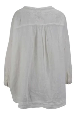 White cotton boho shirt with braided straps at the front and pockets on the sides. Adorned with embroidery and  fringes hem