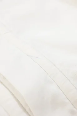 White cotton button-front shirt featuring Oxford-style collar and concealed button placket