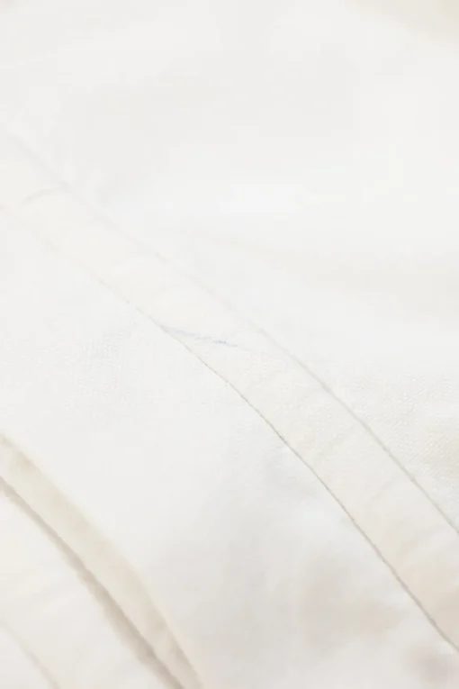 White cotton button-front shirt featuring Oxford-style collar and concealed button placket