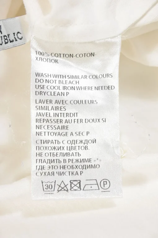 White cotton button-front shirt featuring Oxford-style collar and concealed button placket
