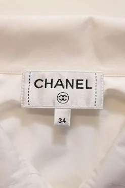 White cotton poplin high-collar button-front shirt featuring pintuck bib and gathered bishop sleeves