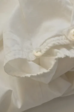 White cotton poplin single breasted notch lapel plunge neck blouse with flutter sleeve appliqué
