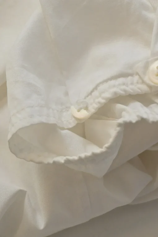 White cotton poplin single breasted notch lapel plunge neck blouse with flutter sleeve appliqué