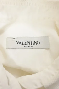 White cotton poplin spread collar button-front swing-style shirt with ruffled hem