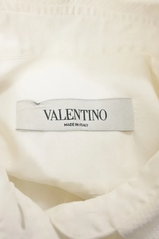 White cotton poplin spread collar button-front swing-style shirt with ruffled hem
