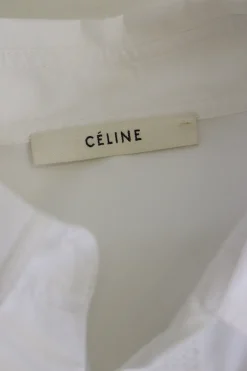 White cotton-blend pullover shirt with classic collar, button cuffs, and round hem