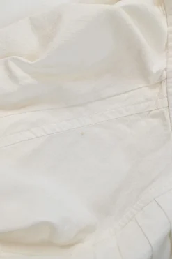 White shirtwaist-style stand collar button-front peplum blouse with pintuck bib and raglan sleeves