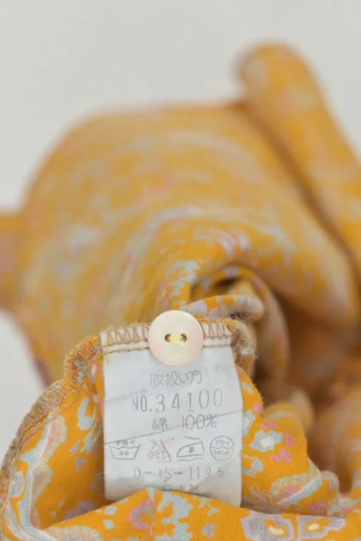 Yellow cotton voile paisley print button-front collarless long sleeve blouse