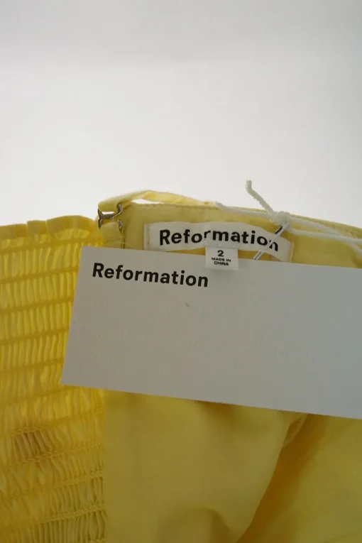 Yellow organic cotton-blend draped foldover bustier top with smocked back and adjustable spaghetti straps
