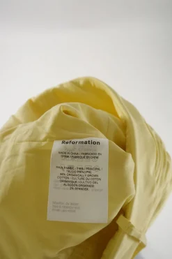 Yellow organic cotton-blend draped foldover bustier top with smocked back and adjustable spaghetti straps